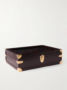 an empty brown suitcase sitting on top of a white surface