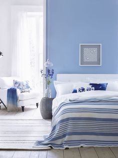 a bedroom with blue walls and white furniture