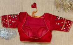 Stunning red mirror work saree blouse. Buy designer blouse in USA from Pure Elegance. Disclaimer: The actual product may vary slightly from the image. These are custom orders, hence expect slight variation in color, placement of the motif or buta. ESTIMATED DELIVERYBecause this is a custom order, it would take about 4 weeks from the date of purchase. RETURN POLICY: This product is a custom order and cannot be returned or exchanged. Red Fitted Sets With Mirror Work, Fitted Embroidered Red Saree, Red Chanderi Blouse Piece For Puja, Designer Red Saree With Mirror Work, Designer Wear Red Choli With Motifs, Red Designer Tops For Festivals, Red Designer Top For Festivals, Designer Red Tops For Festivals, Designer Red Top For Festivals