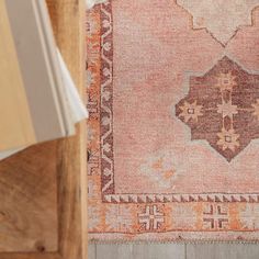 an old rug is laying on the floor next to a wooden box and some books