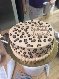 a birthday cake with leopard print frosting sitting on top of a table next to other items