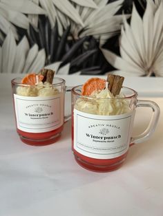 two mugs filled with food sitting on top of a table