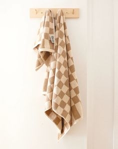 a towel hanging on the wall next to a coat rack