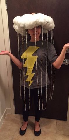 a child wearing a cloud hat with chains hanging from it's head and lightning bolt on top