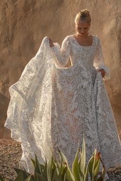 a woman in a white dress is walking on the beach