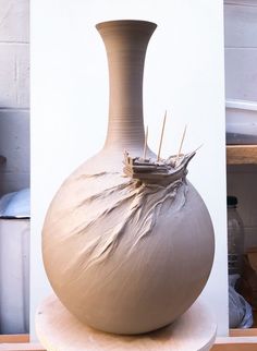 a large vase sitting on top of a wooden table