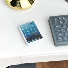 a cell phone sitting next to a calculator on top of a white table