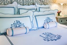 a bed with blue and white pillows on top of it