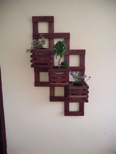 a wall mounted planter made out of wooden pallets with plants growing in them