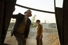 an older man standing next to a young boy