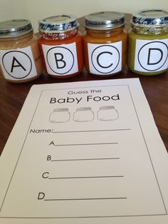 four jars of baby food sit on a table next to a paper with the words abcd