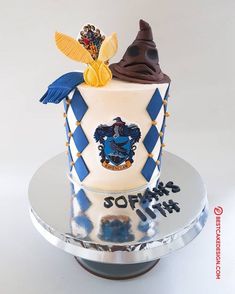 a birthday cake with a harry potter crest on top and hogwarts hat on top