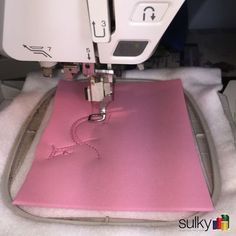 a pink piece of fabric being sewn with a sewing machine on top of it