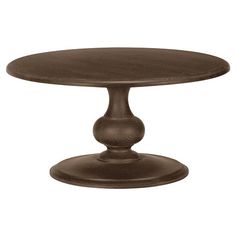 a round wooden table with an ornate design on the top and base, against a white background