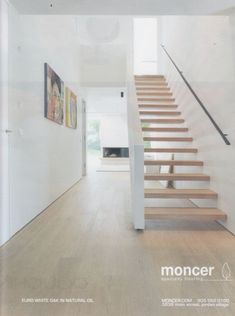 a white staircase with wooden steps leading up to the second floor