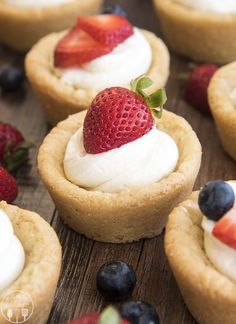 small desserts with strawberries and blueberries are on a wooden table, ready to be eaten