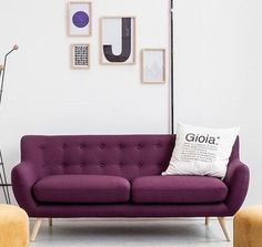 a purple couch sitting in front of a white wall