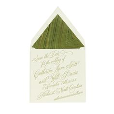 an envelope with green and white calligraphy on the inside is open to reveal a wedding card