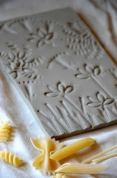 some pasta and noodles on a white table cloth next to a cookie molding sheet