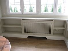 an empty room with two windows and a radiator