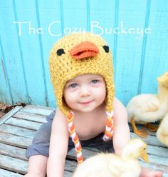 a young child wearing a crocheted ducky hat