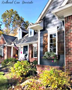 a brick house with shutters and flowers in the window boxes on the front porch