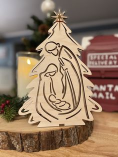 a wooden christmas tree ornament with the image of mary and jesus on it