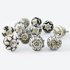 an assortment of black and white flower knobs on a white surface with one button facing the camera