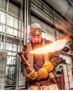 a man holding a fire extinguisher in front of a large metal building