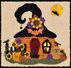 a quilted halloween scene with a witch's hat on top of a house