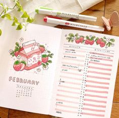 an open planner with strawberries on it next to two markers and a pencils