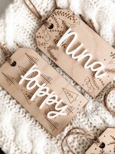 two wooden tags with the words happy on them sitting on top of a white blanket