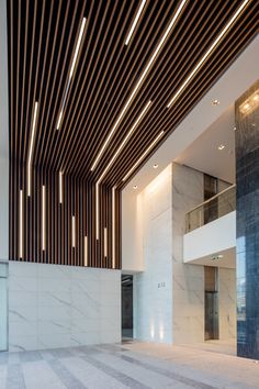 the interior of a building with marble floors and walls, along with wooden slats