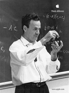 a man standing in front of a blackboard while holding something up to his hand