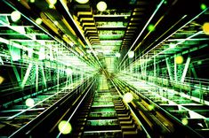 an abstract image of green and yellow lights in a tunnel with train tracks running through it