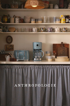 the kitchen counter is covered with dishes, cups and coffee maker's on it