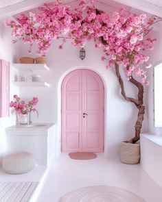 a pink door in the corner of a room with white walls and flooring is decorated with flowers