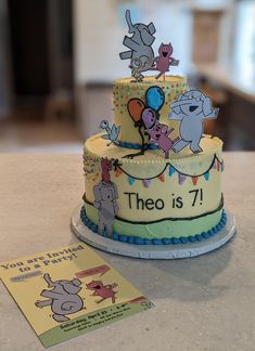 there is a birthday cake with animals on it and a card next to the cake