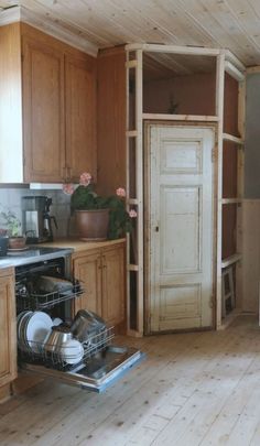 an open dishwasher sitting inside of a kitchen