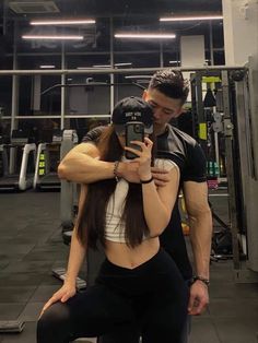 a man and woman taking a selfie in the gym