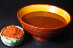 a bowl of soup next to a small bowl of powder