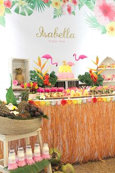 a tropical themed dessert table with pineapples, coconuts and other food items