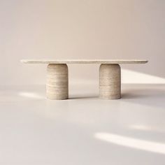 a white table sitting on top of a white floor next to a light colored wall