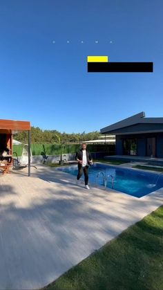 two people standing in front of a swimming pool with an open patio area next to it