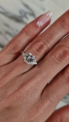 a woman's hand with a ring on it and a diamond in the middle