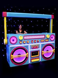 a woman sitting on top of a boombox with lights in the dark behind her