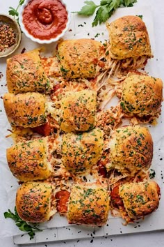 the bread is covered with cheese and sauces on paper next to other food items