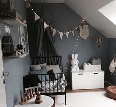 an attic bedroom is decorated in black and white with buntings strung from the ceiling