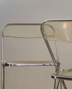 a close up of a metal folding chair against a white wall with no one sitting in it