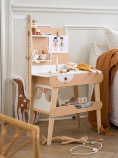 a child's desk and chair in the corner of a room with toys on the floor